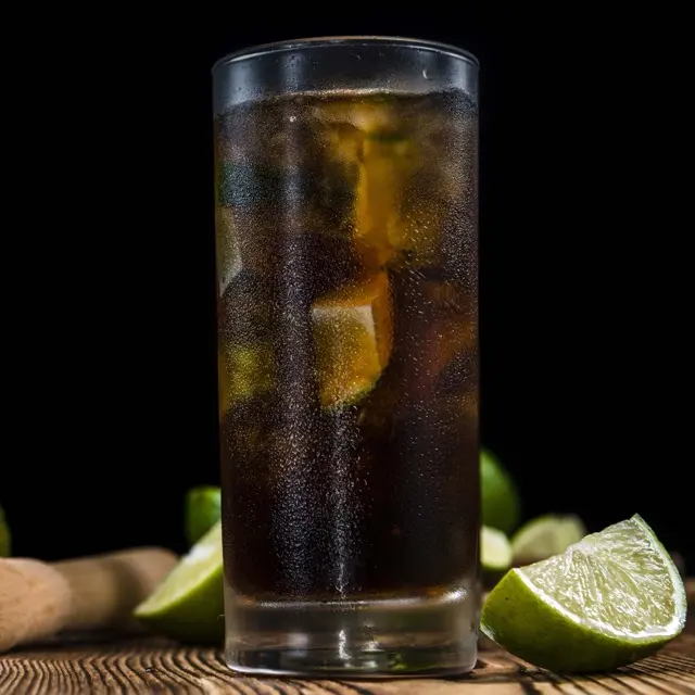 Cuba Libre with cola, ice and lime wedges